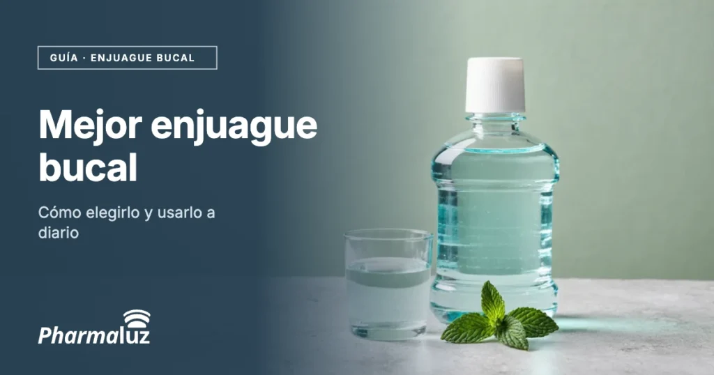 Botella de enjuague bucal con líquido azul y vaso de cristal con hojas de menta